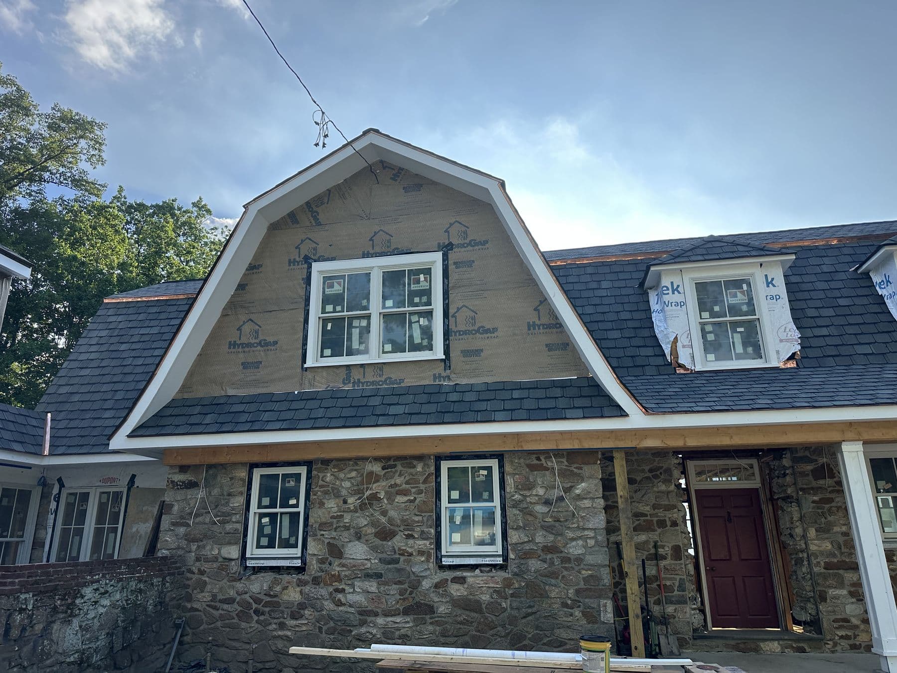 Gambrel end and dormers above the original fieldstone walls
