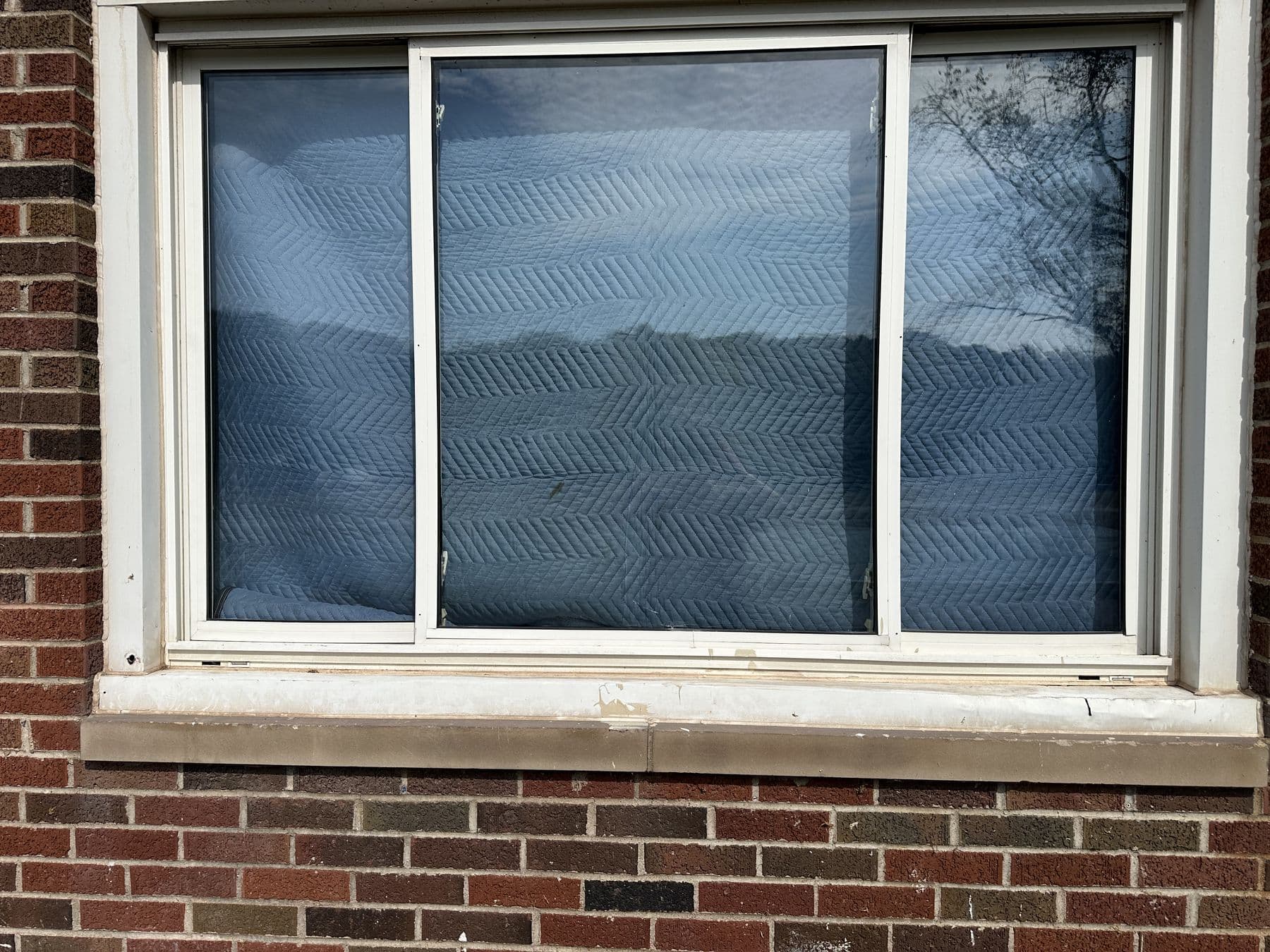 Two new sliding windows in a brick house with stone sills