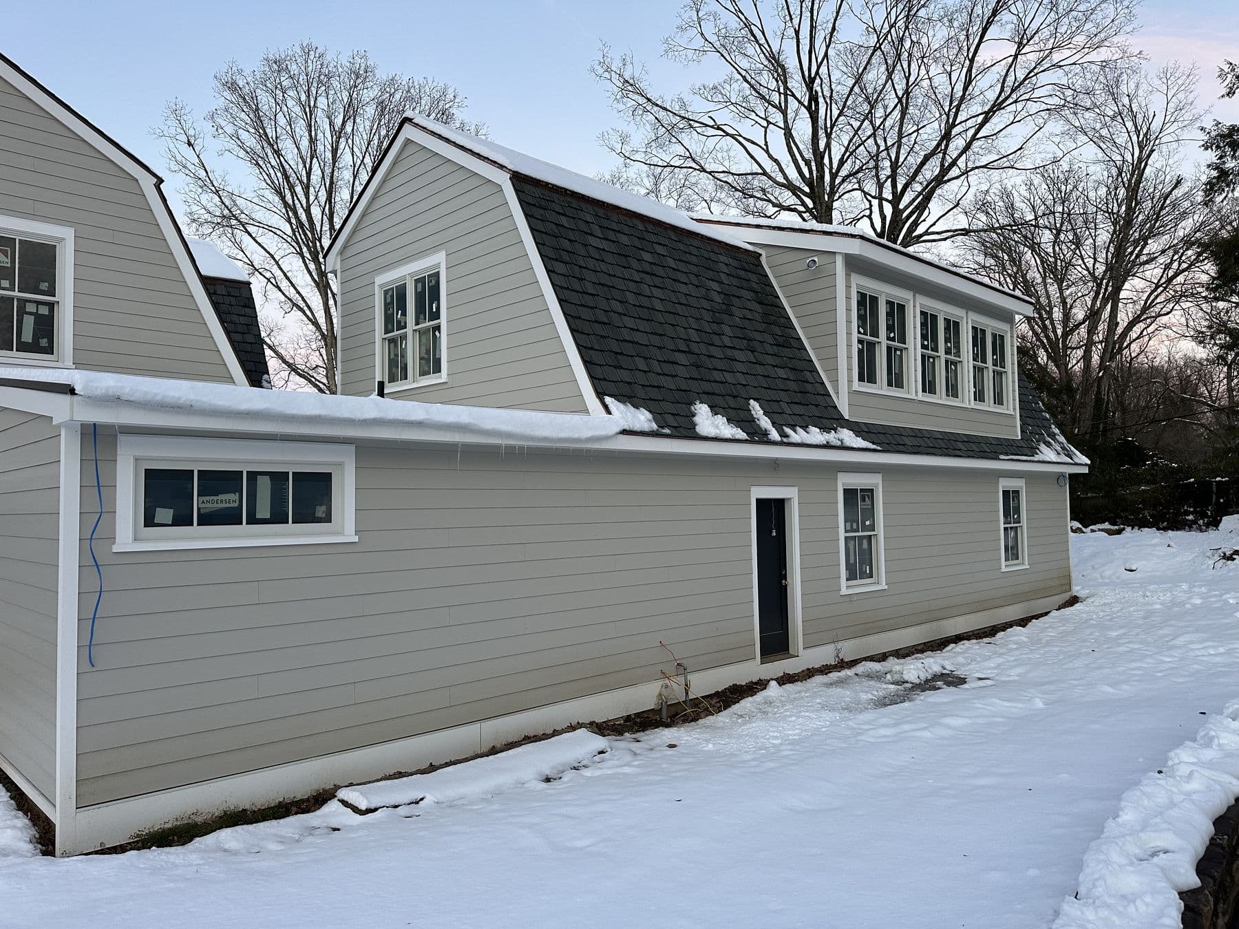 Long side of the addition in lap siding with new windows, snow on the ground