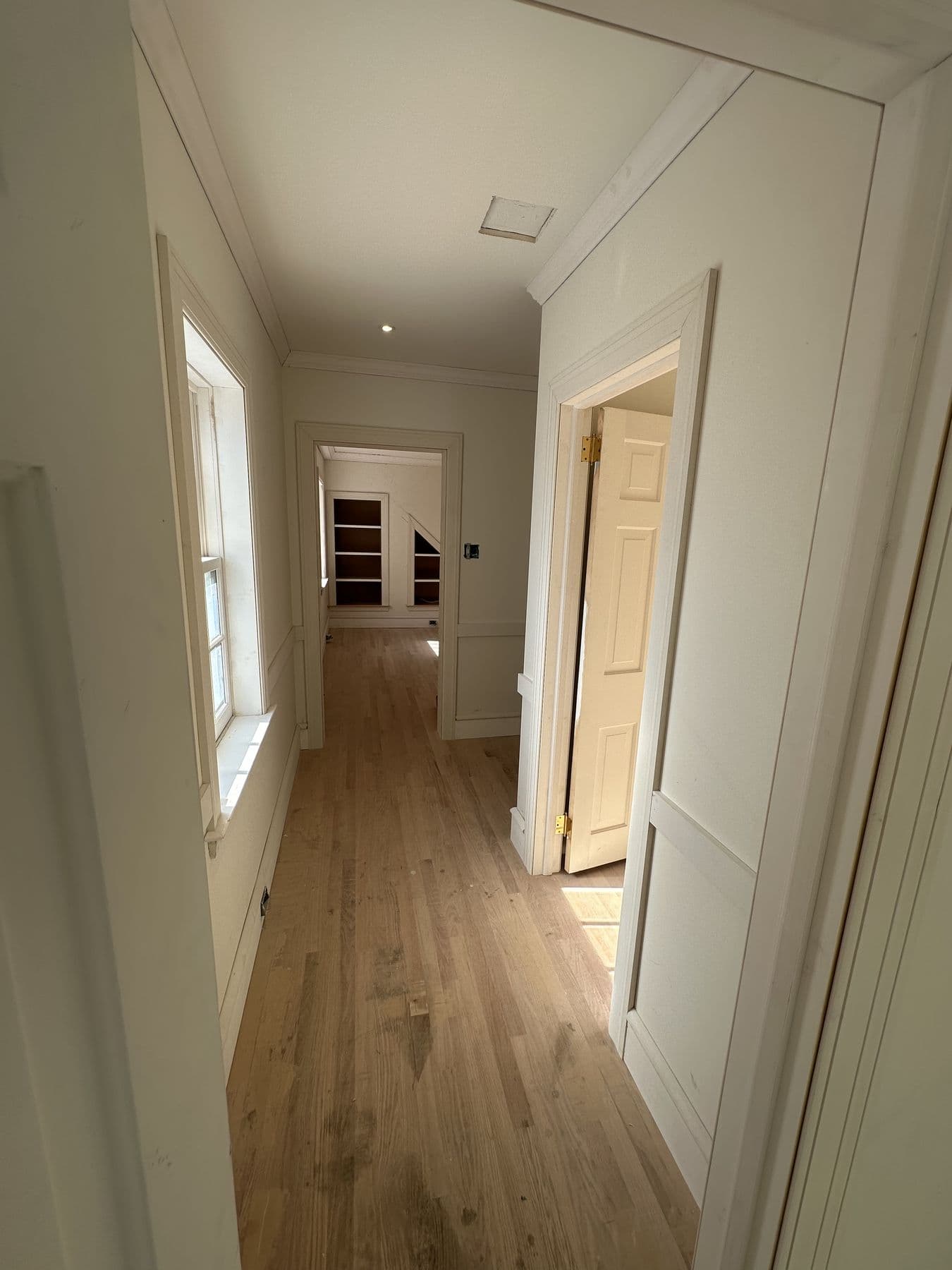 Long hallway view with new doors, trim and oak flooring