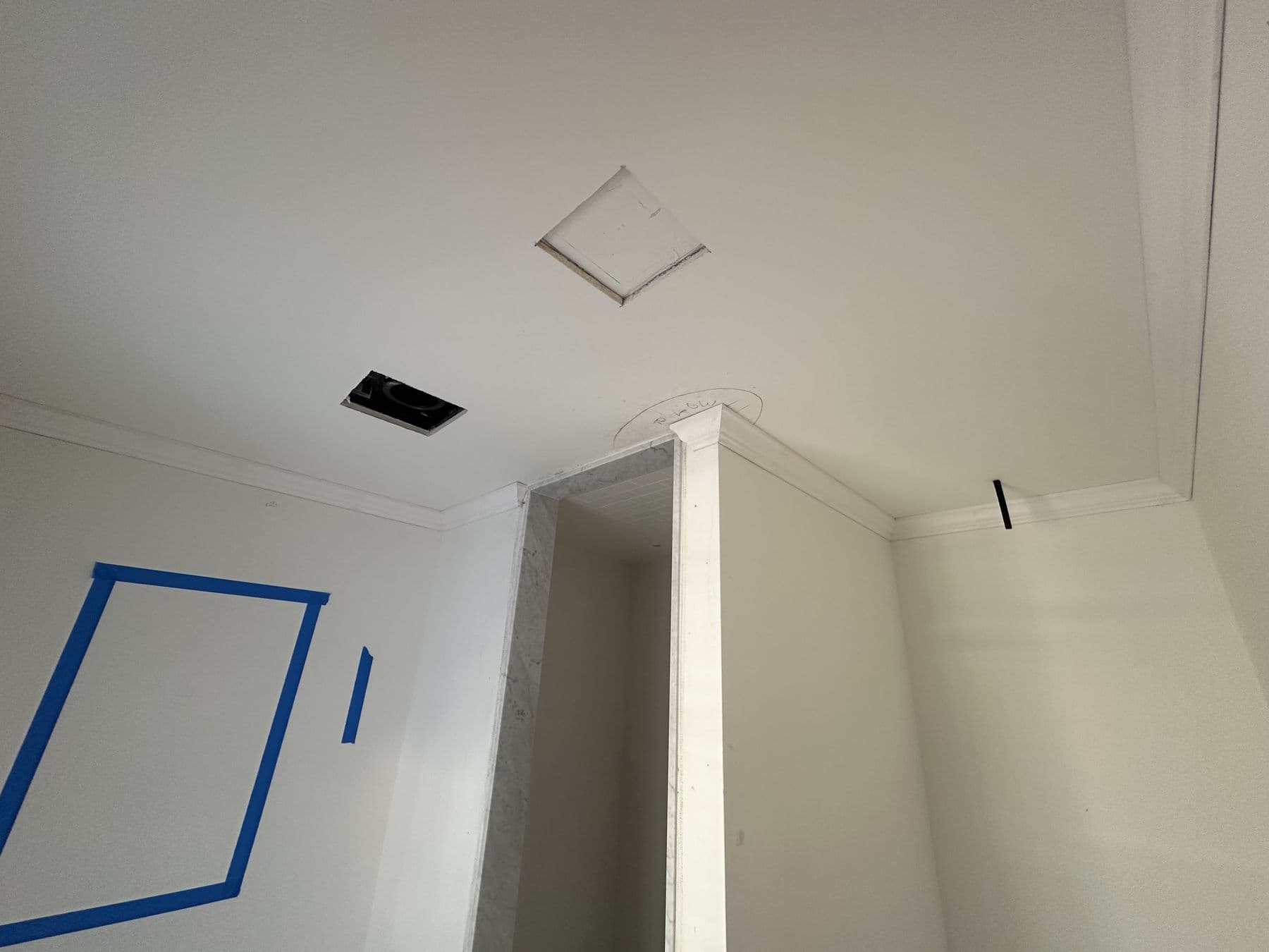 Attic hatch and knee wall opening marked with tape before trim