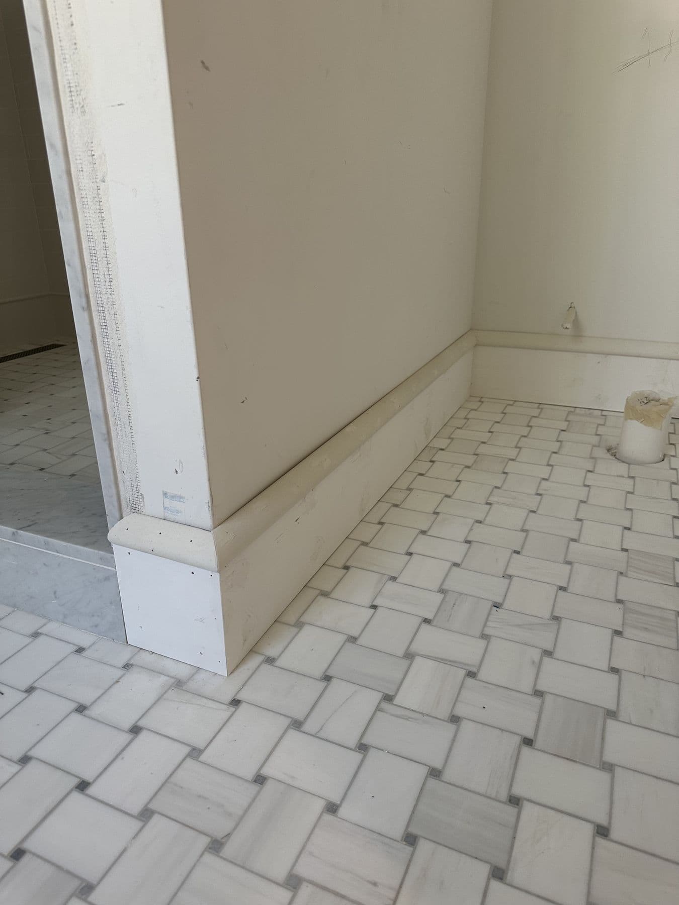Base cap and shoe on a marble basketweave tile floor