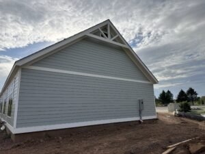Light gray lap siding gable with white trim and a decorative gable truss on a single-story home