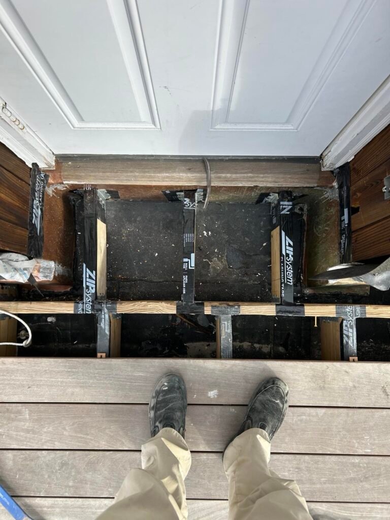 ZIP System flashing tape waterproofing a door threshold above deck framing during construction