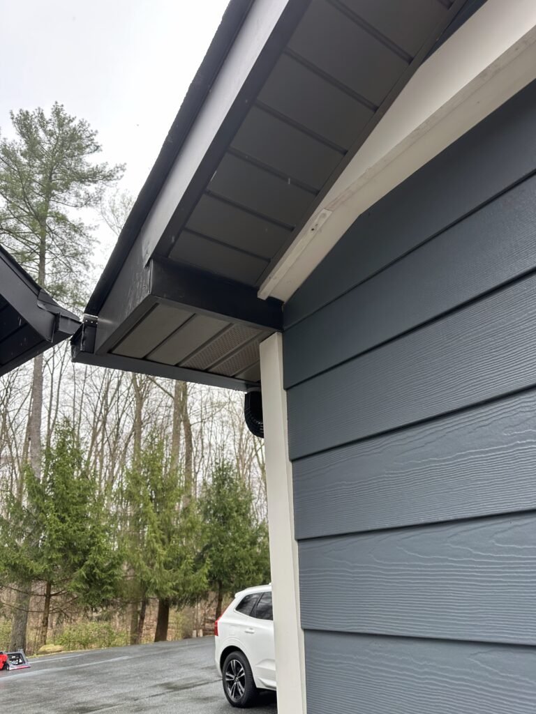 Dark gray fiber cement lap siding with white trim and black gutters installed on a residential garage in Denver PA Lancaster County by D&E Mako Renovation