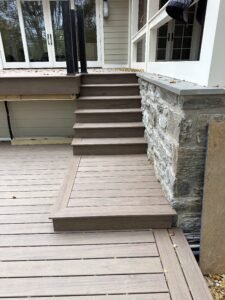 Composite deck stairs with pressure-treated framing and stone wall bluestone cap during deck construction in Lititz PA Lancaster County by D&E Mako Renovation