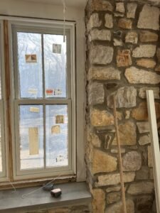 New Andersen double-hung window with divided lites installed in a thick fieldstone wall