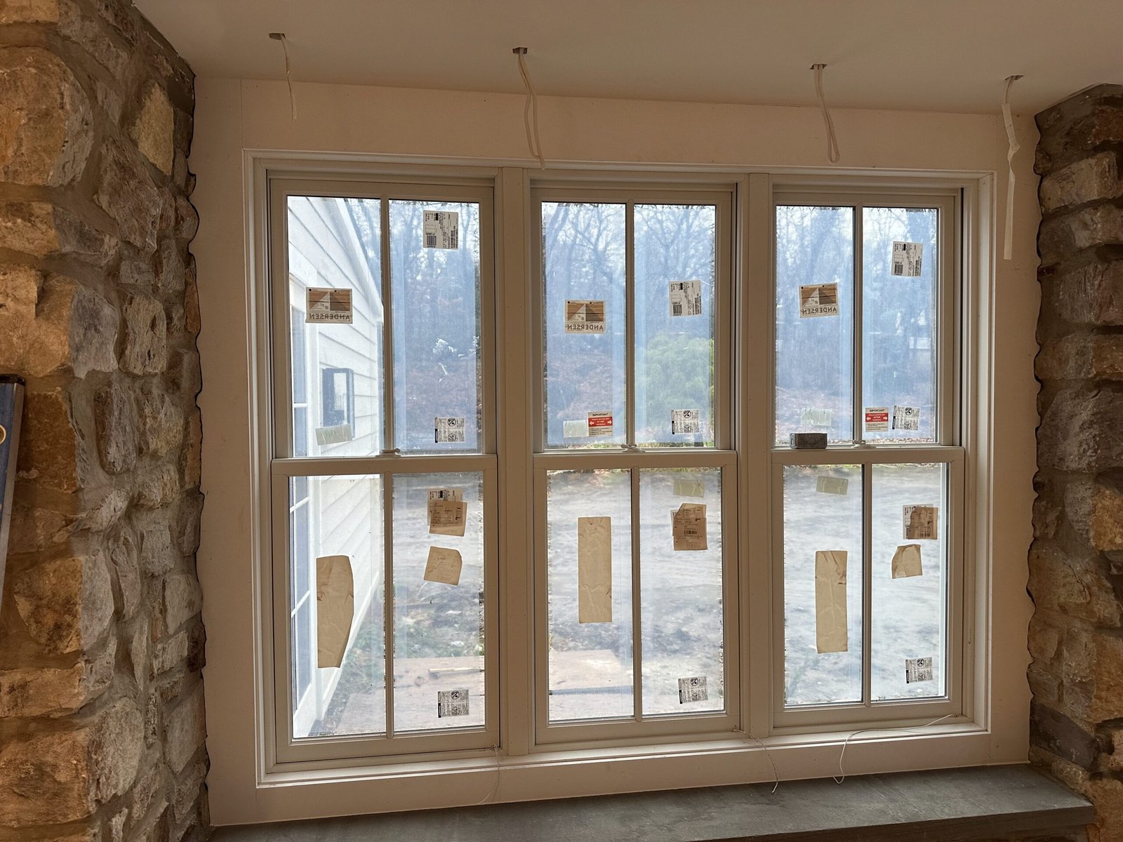 Andersen double-hung windows freshly installed in a stone home interior near Malvern PA by D&E Mako Renovation