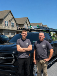 Two D&E Mako Renovation team members in front of a black work truck in a Lancaster County PA neighborhood